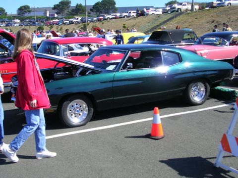 1996 Ford Probe - A green coupe with custom wheels is displayed at a car show, with other vehicles and spectators in the background.