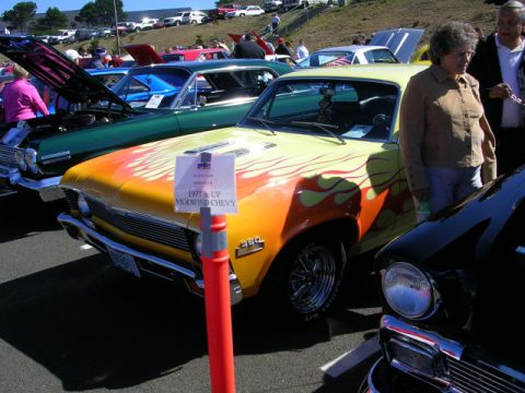 1996 Ford Probe - A modified Chevy with flame graphics is displayed at a car show, alongside other vehicles.