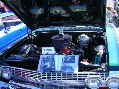 1996 Ford Probe - The engine bay of a green car is displayed with an open hood, revealing the engine and other components.