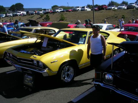 1996 Ford Probe - Yellow 1969 Chevrolet Chevelle SS on display at a car show, with its hood open.