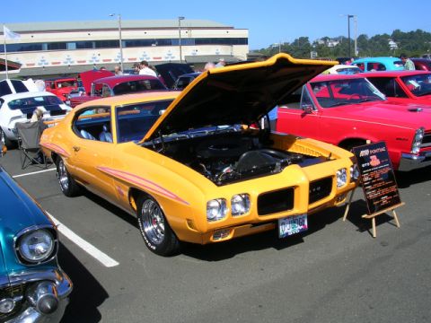 1996 Ford Probe - A classic 1970 Pontiac GTO "The Judge" is displayed with its hood up at an outdoor car show.