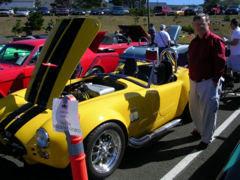 1996 Ford Probe - Modified Ford Cobra replica on display at a car show, racing stripes and an open hood.