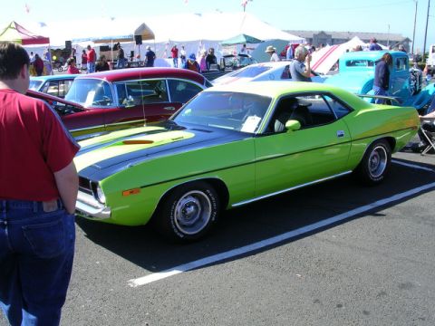 1996 Ford Probe - A lime green muscle car with black racing stripes is parked at a car show.