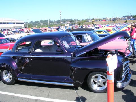 1996 Ford Probe - A collection of cars are displayed at an outdoor event under a clear sky.