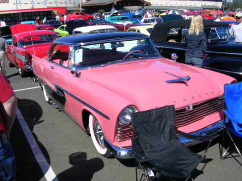 1996 Ford Probe - A classic 1955 Plymouth Belvedere coupe is displayed at a car show with other vehicles in the background.