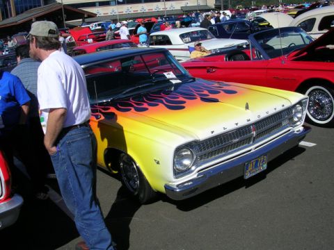 1996 Ford Probe - A classic Plymouth Belvedere with custom flame paint job at a car show.