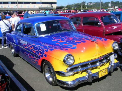 1996 Ford Probe - Custom 1953 Chevrolet Bel Air hot rod with flame paint job at a car show.