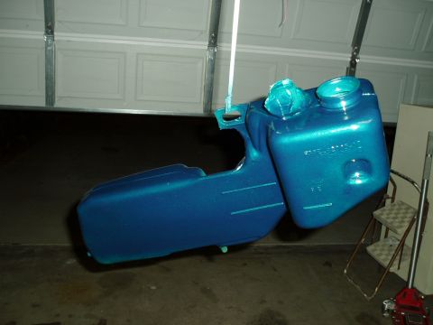 1993 Ford Taurus - A freshly painted blue metallic fuel tank hangs suspended, ready for installation.