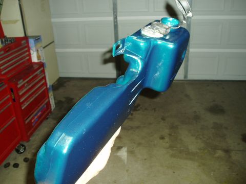 1993 Ford Taurus - Custom painted car part with metallic teal and blue finish, held in front of a garage.