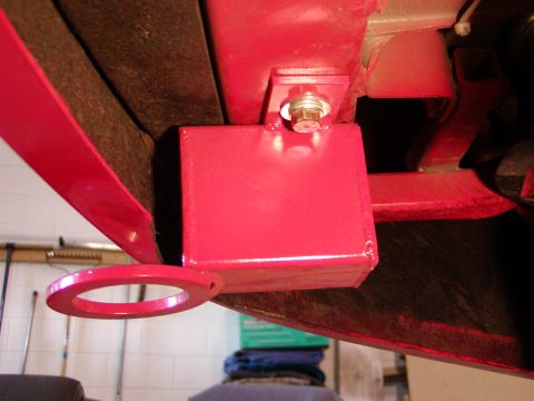 2003 Ford Mustang - Close-up of a red tow hook assembly attached to a vehicle's undercarriage.