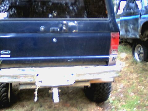 1987 Ford Bronco II - Rear view of a 1987 Ford Bronco II, with another vehicle partially visible in the background.