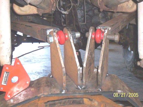 1994 Ford Bronco - Custom suspension part fabrication with red bushings and a magnetic welding guide visible.