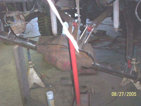1994 Ford Bronco - The photo shows a vehicle's rear axle assembly being worked on, with suspension parts and a brake caliper visible.