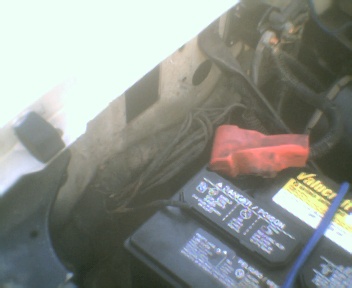 1989 Ford Bronco - Close-up view of an engine bay, focusing on the battery and associated wiring.
