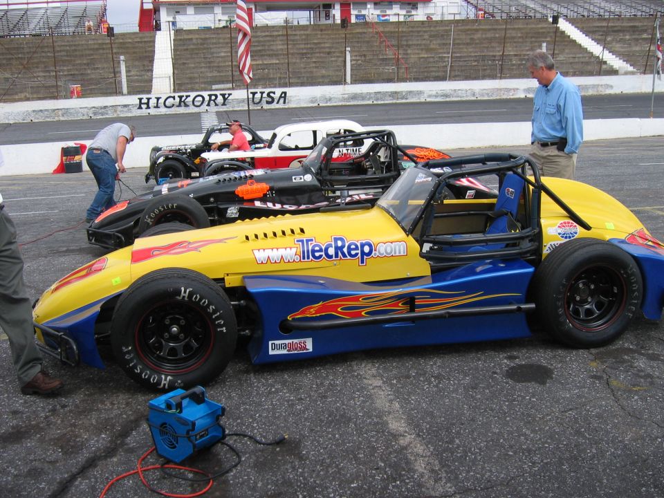 Yellow and blue race car with flames and "www.TecRep.com" on side