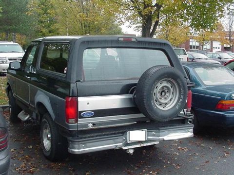 1993 Ford Bronco - Rear view of a 1993 Ford Bronco parked in a lot with other vehicles.