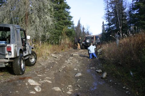 2003 Jeep TJ - Jeep Wranglers navigate a challenging off-road trail through a wooded area.