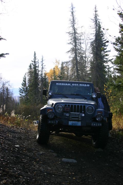 2003 Jeep TJ - Jeep TJ on a dirt road with trees in the background.