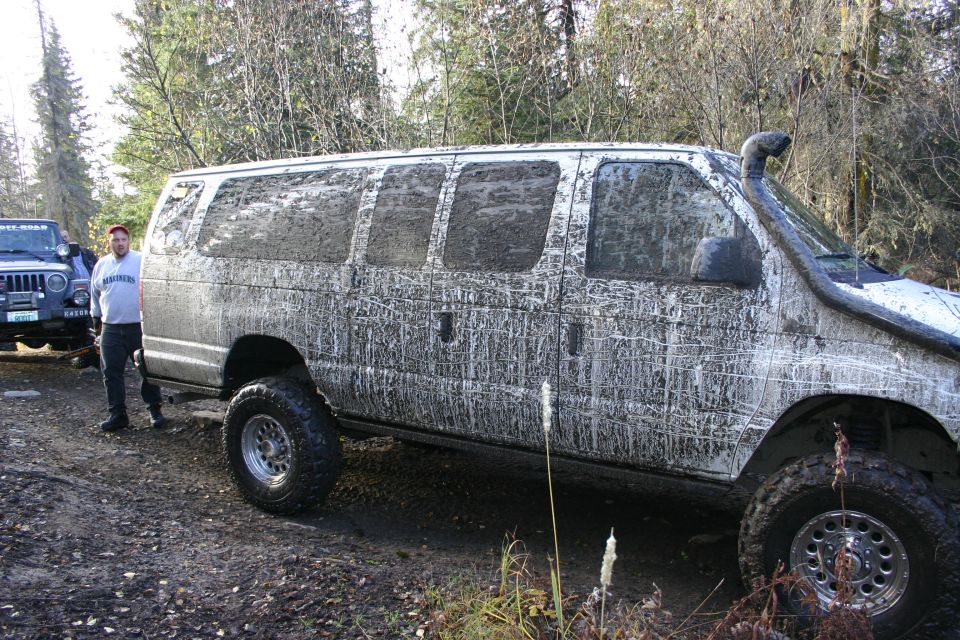 Muddy van with snorkel and a Jeep in the background
