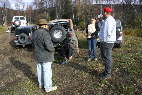 2003 Jeep TJ - A group of people stand around a black Jeep Wrangler in an outdoor setting.