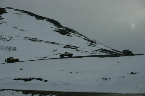 2003 Jeep TJ - Several vehicles navigate a treacherous, snow-covered mountain pass.