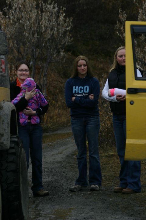 2003 Jeep TJ - Three women and a baby are gathered outdoors near a yellow vehicle.