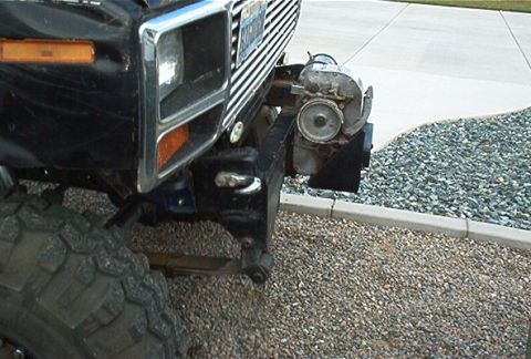 1986 Ford Bronco - Close-up of a vintage Ford Bronco's front end, a winch and off-road tire.