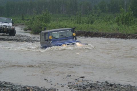 2003 Jeep TJ - Two Jeeps navigate a water crossing, with the lead vehicle partially submerged.