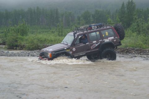 2003 Jeep TJ - Modified Jeep Cherokee XJ navigating a river during an off-road excursion.