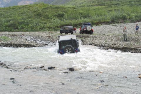 2003 Jeep TJ - Jeep TJ navigating a river crossing with other vehicles and spectators present.