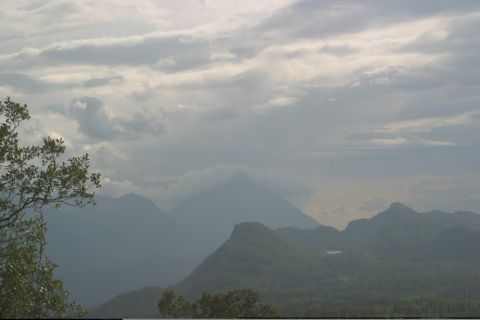 2003 Jeep TJ - A scenic view of mountains and clouds, with foliage in the foreground.