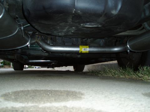 1993 Ford Taurus - The underside of a vehicle reveals a newly installed exhaust system with a yellow label attached to the pipe.