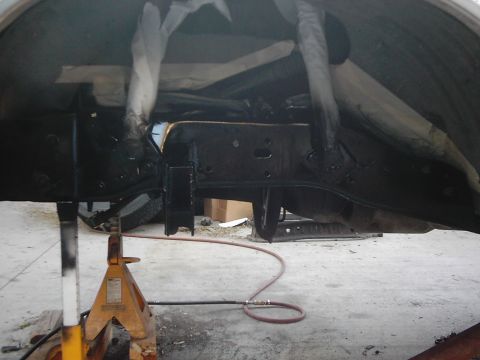1978 Ford Bronco - The vehicle's frame and suspension are visible while it's supported by jack stands.