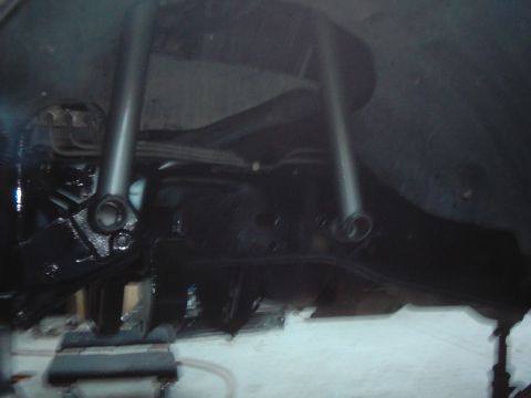 1978 Ford Bronco - The underside of a vehicle shows its suspension system, with dark-colored components and shock absorbers.