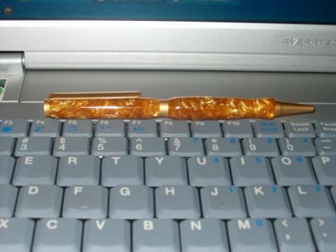 1995 Ford Bronco - A gold marbled pen rests on the keyboard of a silver laptop.
