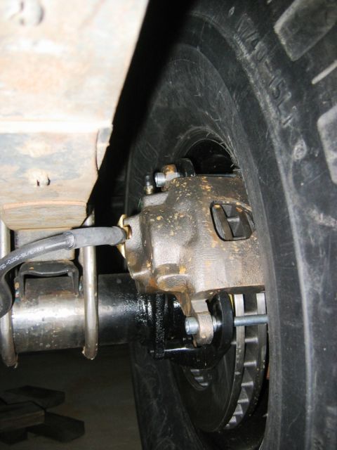 1985 Ford Bronco - Close-up view of a vehicle's rear brake caliper and rotor assembly, likely part of a modification or repair.