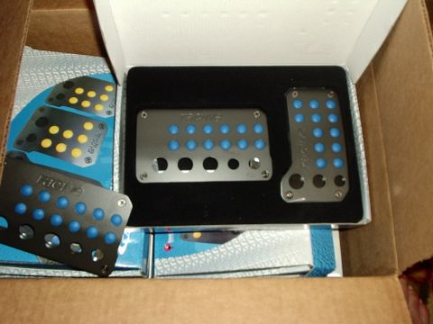 2000 Ford Taurus - New aluminum pedal covers with blue inserts are shown in their packaging.