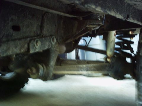 1986 Ford Bronco - Close-up view of the undercarriage of a vehicle, focusing on the suspension system.