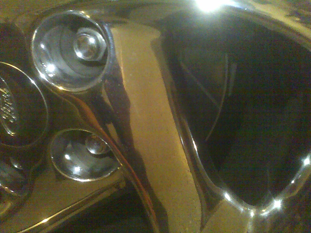 Chrome wheel with visible lug nuts and a faint 'Ford' logo