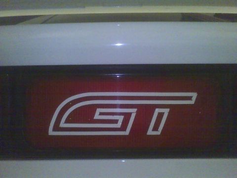 1996 Ford Probe - Close-up of a GT emblem on a red background with a watermark.