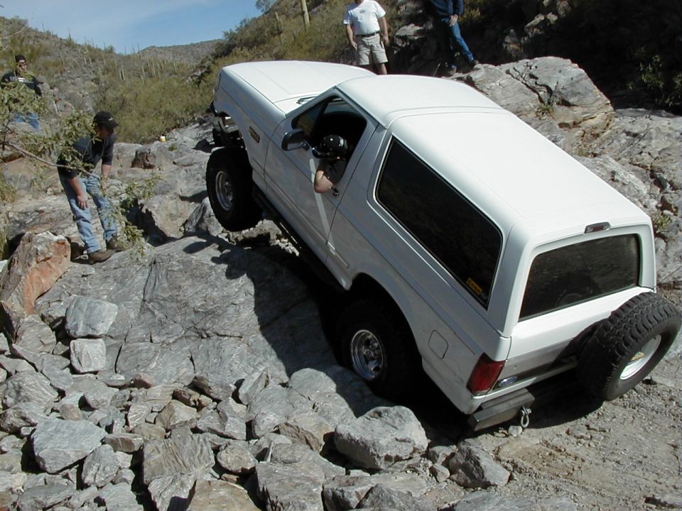 1993 Ford Bronco navigating a rocky trail, driver visible