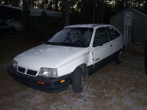 1995 Ford Bronco - This white hatchback has visible damage and rust, indicating it is not in condition.