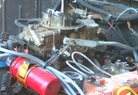 1978 Ford Bronco - Close-up view of an engine's carburetor and associated components.