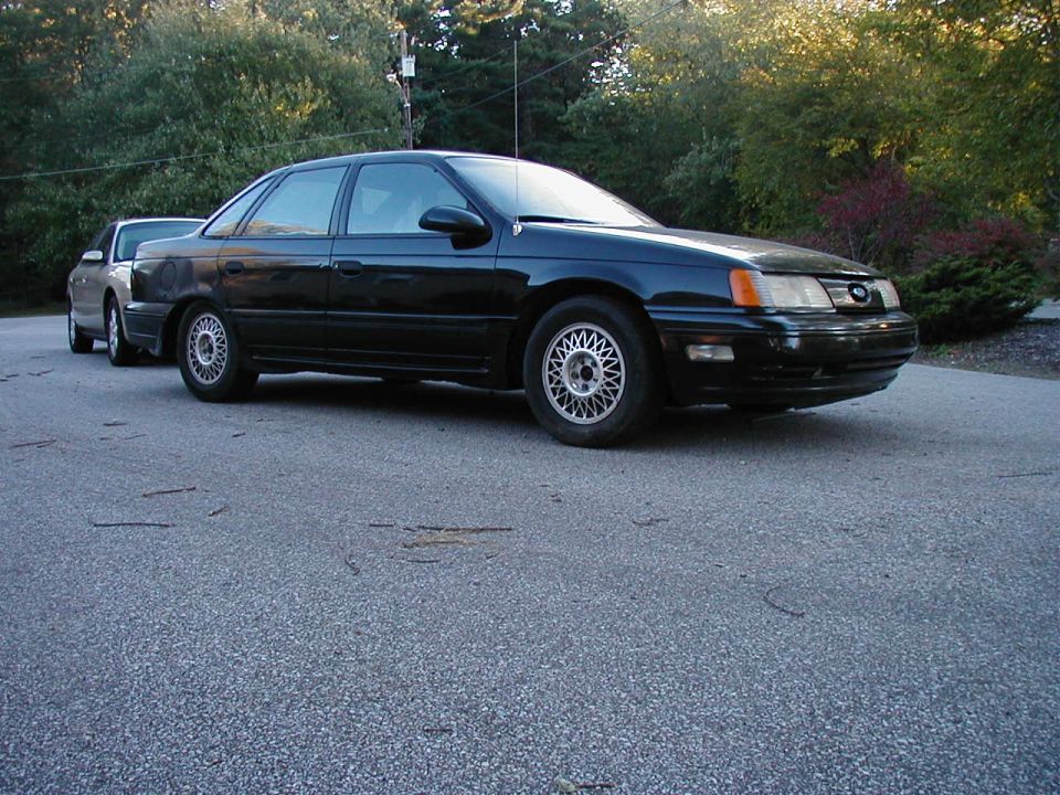 Black 1990 Ford Taurus sedan, 3/4 front view
