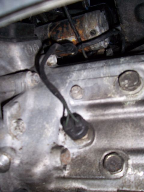 1991 Ford Probe - This is a close-up view of a component within a vehicle's engine bay, showing wiring and metal parts.