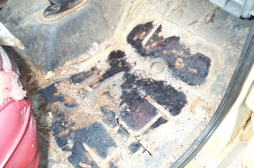 Interior floor pan with rust and dark stains