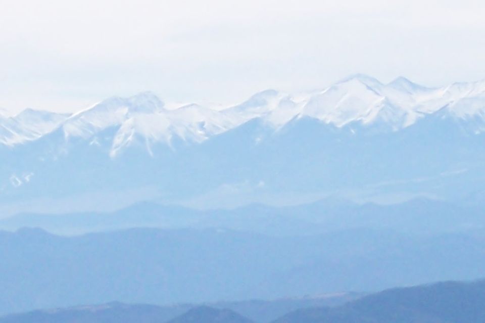 Snow-capped mountains under a hazy sky
