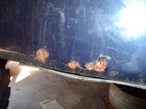 1984 Ford Bronco - Rust damage is visible on the lower body panel of this vehicle.