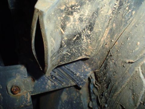 1984 Ford Bronco - Close-up view of a dirty fender liner and its mounting hardware.