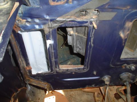 1984 Ford Bronco - The interior of a vehicle shows exposed metal, rust, and open cavities during a rebuild.